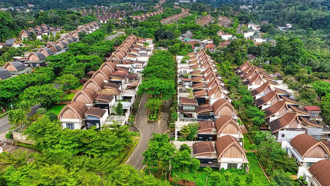 Aerial view of rows of houses and tree-lined roads in a tropical housing estate